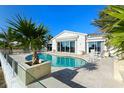 Inviting kidney-shaped pool with a stone deck and glass railing at 6061 Gulf Of Mexico Dr, Longboat Key, FL 34228