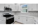 Modern kitchen featuring stainless steel appliances, white cabinets, and sleek countertops for a contemporary feel at 6107 Mesa Gln, Bradenton, FL 34203