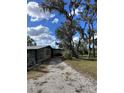 Home showcasing side yard and mature oak trees with Spanish moss at 6504 Lincoln Rd, Bradenton, FL 34203