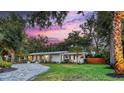 Charming home with a circular driveway, manicured lawn and exterior lighting at 730 40Th St, Sarasota, FL 34234