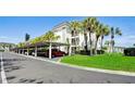 Condo building with covered parking and lush green landscaping at 4330 Falmouth Dr # 108, Longboat Key, FL 34228