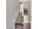 Interior staircase with hardwood floors, carpeted stairs, neutral walls, and white trim and doors at 461 Nokomis S Ave, Venice, FL 34285