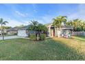 Landscaped yard with palm trees and festive decorations at 4877 Post Pointe Dr, Sarasota, FL 34233