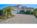 Charming two-story home with tropical landscaping, a two-car garage, and a beautiful brick driveway at 5035 Kiva Cir, Bradenton, FL 34211