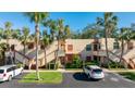 Charming condo complex with palm trees and well-kept landscaping, with private stairs leading to each unit entrance at 527 Spring Lakes Blvd, Bradenton, FL 34210