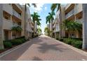 Lush landscaping lines a brick road leading to condo buildings at 5968 Midnight Pass Rd # 164, Sarasota, FL 34242