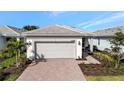 Front view of the house showing a two-car garage and landscaping at 10358 Abaco Falls Dr, Englewood, FL 34223