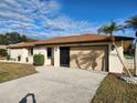 Light beige home with brown roof and a garage door at 25484 Terrain Ln, Punta Gorda, FL 33983