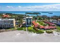 Stunning aerial view showcasing building next to a sandy beach and the blue ocean waters at 4241 Gulf Of Mexico Dr # 202, Longboat Key, FL 34228