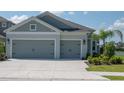 Two-story house with gray siding, two-car garage, and landscaped yard at 4406 Rustling Pines Ter, Parrish, FL 34219