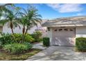 Exterior view of villa, showcasing garage and lush landscaping at 5535 Hampstead Heath # 45, Sarasota, FL 34235