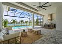 Spacious outdoor living area with a stylish seating area, dining area, and view of the pool and lake at 8328 Sea Glass Ct, Sarasota, FL 34240