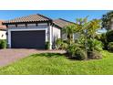 House exterior showcasing landscaping and a gray garage door at 8752 Bellussi Dr, Sarasota, FL 34238