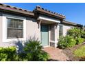 Teal front door entryway with brick walkway and lush landscaping at 8752 Bellussi Dr, Sarasota, FL 34238