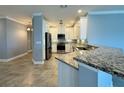 Modern kitchen with white cabinets, granite countertops, and stainless steel appliances at 3404 79Th Street W Cir # 203, Bradenton, FL 34209