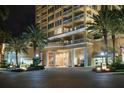 Night view of building entrance with palm trees and columns at 35 Watergate Dr # 804, Sarasota, FL 34236