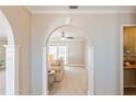 View through arched doorway showing living room with neutral decor and access to backyard at 3808 El Conquistador Pkwy, Bradenton, FL 34210