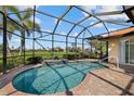 Screened in pool with brick patio and view of green field and sunny sky at 4423 Via Del Villetti Dr, Venice, FL 34293