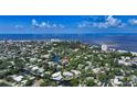 Breathtaking aerial of a neighborhood near the beach and water, featuring the property with a circle marker at 4815 Featherbed Ln, Siesta Key, FL 34242