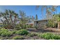 Charming home exterior with a well-maintained yard, landscaping, and mature trees at 640 Venice Ln, Sarasota, FL 34242