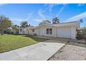 Front view of a single-Gathering home with a driveway and grassy yard at 7720 Judith Cres, Port Richey, FL 34668
