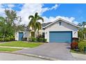 Charming exterior view of home with manicured lawn, brick driveway, palm tree and pleasing landscaping at 931 Mangrove Edge Ct, Bradenton, FL 34208