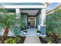 Inviting front porch with white columns and tropical landscaping at 13930 Old Creek Ct, Parrish, FL 34219