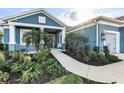 Landscaped front yard with palm trees and walkway leading to the front porch at 13930 Old Creek Ct, Parrish, FL 34219
