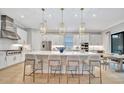 Modern white kitchen with large island, stainless steel appliances, and pendant lighting at 15415 Derna Ter, Bradenton, FL 34211