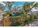 Quaint home with a fenced yard, landscaping, and a blue door at 1802 Cocoanut Ave, Sarasota, FL 34234