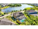 Aerial view of a home with a screened-in pool and lush landscaping, near a lake at 6318 Anise Dr, Sarasota, FL 34238