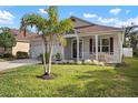 House exterior showcasing a front porch, palm tree, and well-manicured lawn at 11414 Water Willow Ave, Lakewood Ranch, FL 34202