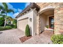 Front entrance with stone detailing and paver driveway at 13031 Palermo Dr, Bradenton, FL 34211