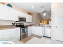 White kitchen with stainless steel appliances and ample counter space at 3927 Mediterranea Cir # 222, Sarasota, FL 34233