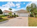 Single-story house with a brick driveway, palm trees, and well-manicured landscaping at 6504 Copper Ridge Trl, Bradenton, FL 34201