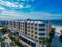 Aerial view of a modern beachfront condo building with a pool and beach access at 915 Seaside Dr # 604, Sarasota, FL 34242