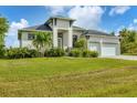Two-story house with a three-car garage, palm trees, and a spacious lawn at 0 Symco Ave, North Port, FL 34286