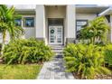 Modern front door entrance with lush landscaping and a stone walkway at 0 Symco Ave, North Port, FL 34286