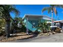 Mobile home with teal exterior and tropical landscaping at 10315 Cortez W Rd # 47-2, Bradenton, FL 34210