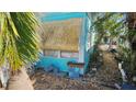 Side view of teal mobile home with tropical landscaping at 10315 Cortez W Rd # 47-2, Bradenton, FL 34210
