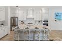 Spacious kitchen boasts white cabinetry, large island, and stainless steel appliances at 11877 Hunters Creek Rd, Venice, FL 34293