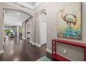 Bright entryway with hardwood floors, red console table, and large artwork at 12606 Fontana Loop, Bradenton, FL 34211