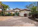 Stunning single-Gathering home with lush landscaping, a brick driveway, a tile roof, and a two-car garage at 4946 Brywill Cir, Sarasota, FL 34234