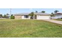 House with a large green lawn and palm trees at 546 Highland Nw Ave, Port Charlotte, FL 33952