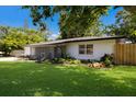 Lovely single-story home showcasing a lush lawn and beautiful landscaping, creating a welcoming exterior at 671 47Th St, Sarasota, FL 34234