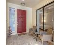 Inviting front porch with red door, wicker chairs, and glass door offering a view inside at 7242 Villa D Este Dr, Sarasota, FL 34238