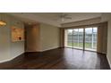 Living room with dark laminate floors and sliding glass doors to patio at 7307 Fountain Palm Cir # 7-102, Bradenton, FL 34203