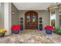 Elegant double front doors with glass inserts, flanked by plants, create a welcoming entrance at 2115 Lychee Ln, Nokomis, FL 34275