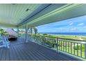 Relaxing covered balcony with ocean view, comfortable seating and durable composite decking at 506 S Casey Key Rd, Nokomis, FL 34275
