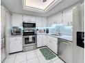 Modern kitchen with stainless steel appliances, white cabinets, and light-blue backsplash at 707 Sorrento Inlt # 707, Nokomis, FL 34275